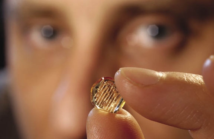 Mark Prausnitz of Georgia Tech’s school of chemical and biomolecular engineering, one of the professors leading a U.S. team in finding a new mass delivery method for the flu vaccine, holds an array of polymer microneedles 1,000 microns tall. This photo, taken by Gary Meek and duplicated from the cover, is used with permission from Georgia Tech.