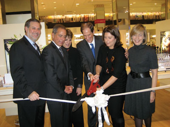 Bloomingdale’s CEO Michael Gould (center, with scissors), joins Nicky Kinnaird (to his right), founder and creative director of Space NK, in cutting the ribbon at the opening ceremony for the new Space NK Apothecary at Bloomingdale’s on 59th Street in New York City.