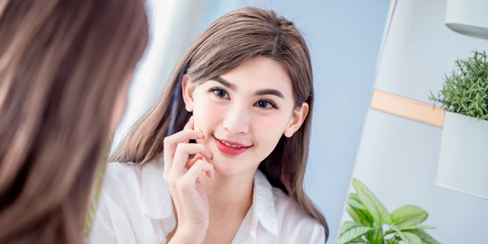 WomanSmilinginMirrorTouchingFaceYoungAsian_850x425