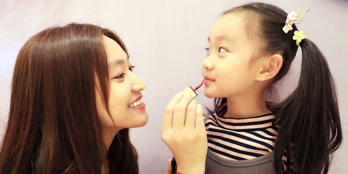 AsianWomanApplyingLipGlossDaughter_850x425