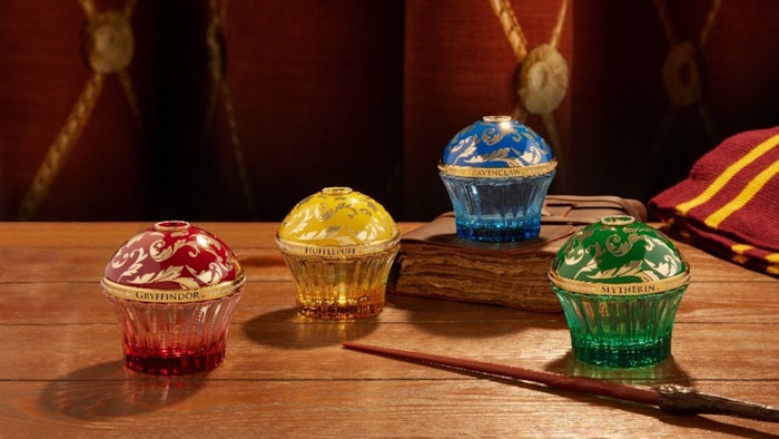 The line includes one candle, a perfume discovery coffret, and four fragrances with matching iconic bow case lipsticks celebrating the four Hogwarts houses.