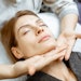 woman receiving lymphatic drainage facial massage in a spa