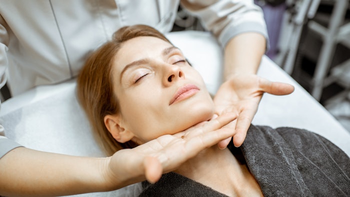 woman receiving lymphatic drainage facial massage in a spa