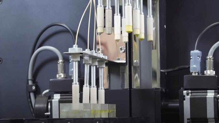 The liquid-liquid encapsulation system introduces a drop of core material through a nozzle, which impacts on a host bath containing a floating shell layer on the surface.