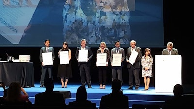 IFSCC Fellows were honored by Tony Gough, IFSCC president (at podium) and Eva Ramos, IFSCC immediate past president (to his left) and included (from far L): Yoichi Yamamato, Ph.D., SCC Japan; Miki Minamino, Ph.D., SCC Japan; Philippe Auderset, Ph.D., Swiss SCC; Amy Wyatt, SCC USA-Canada; Simon Chan, SCC China; and Frederic Leroy, Ph.D., SCC France. Not pictured: Randy Wickett, Ph.D., and Tony O'Lenick, both of the USA