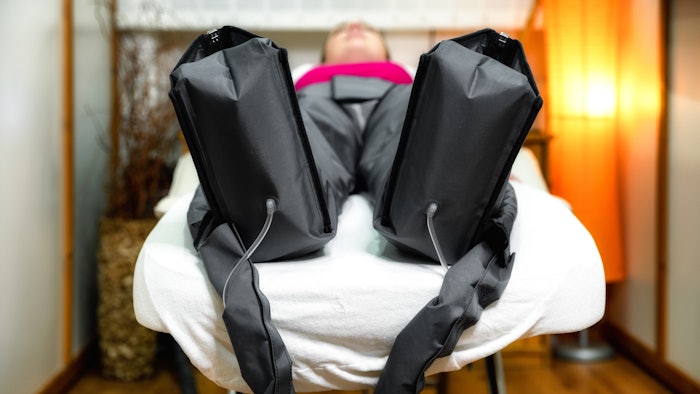 Pressotherapy procedure with overalls in a beauty salon. Modern lymphatic drainage massage. Health and beauty concept