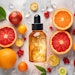 Natural vitamin c serum, skincare, essential oil products. Bottle of vitamin C serum with fresh juicy orange fruit. Beauty product branding mock-up.