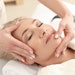 Mature woman receiving face massage in wellness spa