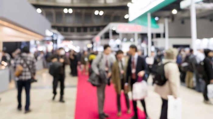 people attending a trade show blurred focus pink carpet