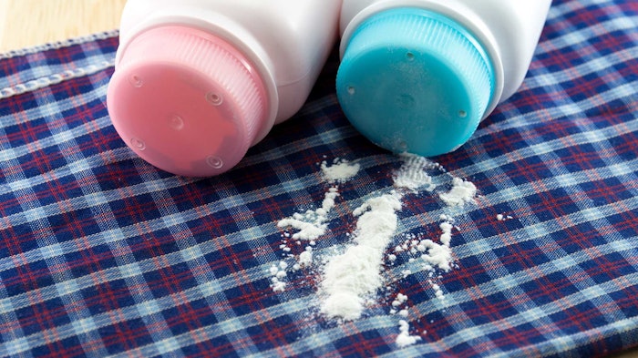 pink blue baby powder bottles spilled on plaid blanket