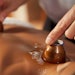 Close-up of a therapist performing a cupping therapy session on a patient, applying cups to the patient's back, soothing clinic background, Portrait close-up, hyper-realistic, high detail,