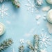 Winter Skin Care products fir branches and snowflakes on blue background