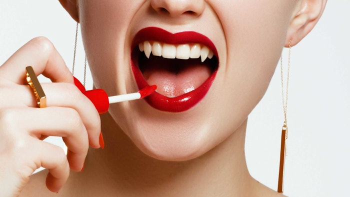 woman-lip-gloss-vampire-teeth-halloween-and-makeup-concept