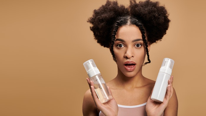 young Black woman pigtails holding products surprised