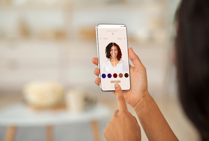 Client using AI app to try on different hair colors.