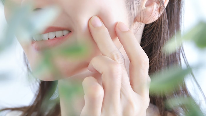 woman jawline touching skin plant in foreground