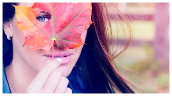 Woman Holding Maple Leaf In Front Of Face Peeking Through Hole Adobe Stock 173772422