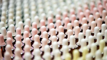 Rows of pastel pink and white textured cylindrical objects with rounded tops