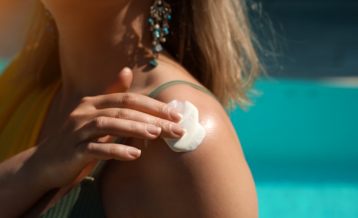 Woman Outside Applying Sunscreen To Shoulder Creamy Foam Concept Adobe Stock 636248390