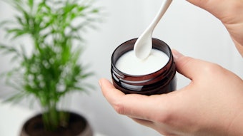 Person Holding Jar Of Skin Cream With Spatula Plant In Background Focus On Hands Adobe Stock 374961360