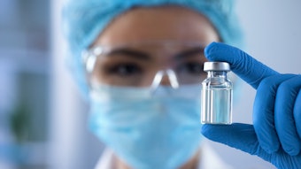 Scientist In Lab Wearing Ppe Holding Small Ampoule Adobe Stock 233949972