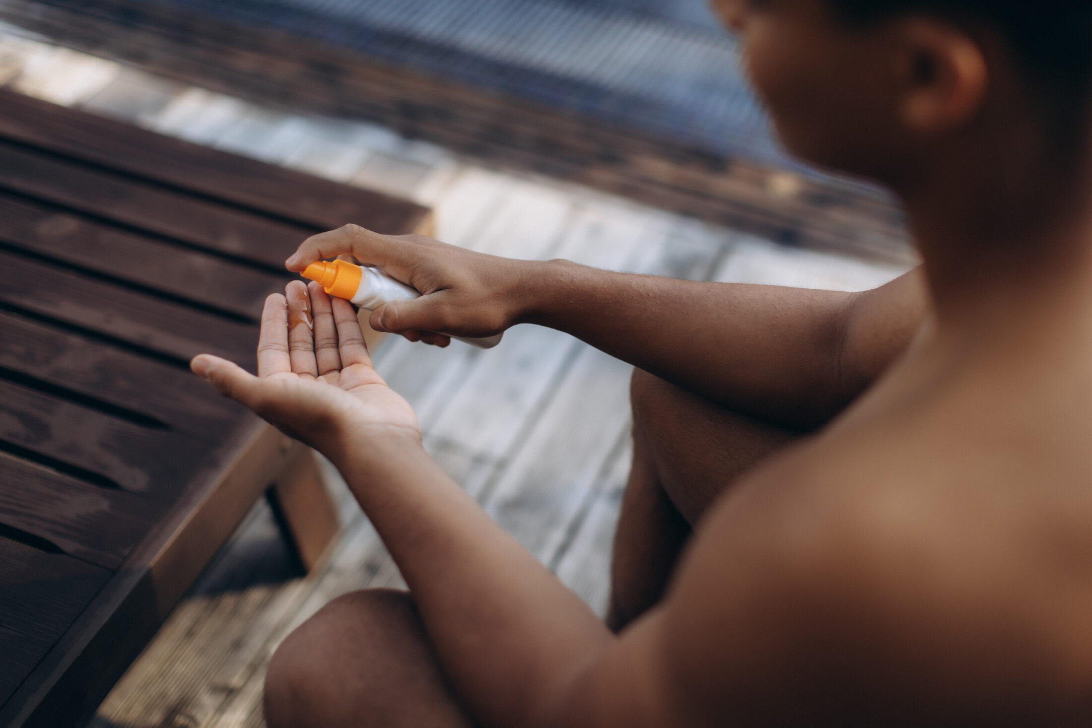 Man By Pool Using Sunscreen Spray Adobe Stock 1726801482