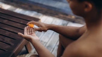 Man By Pool Using Sunscreen Spray Adobe Stock 1726801482
