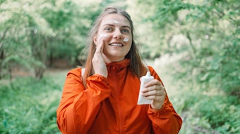 Woman In Forest Using Sunscreen Adobe Stock 612845794