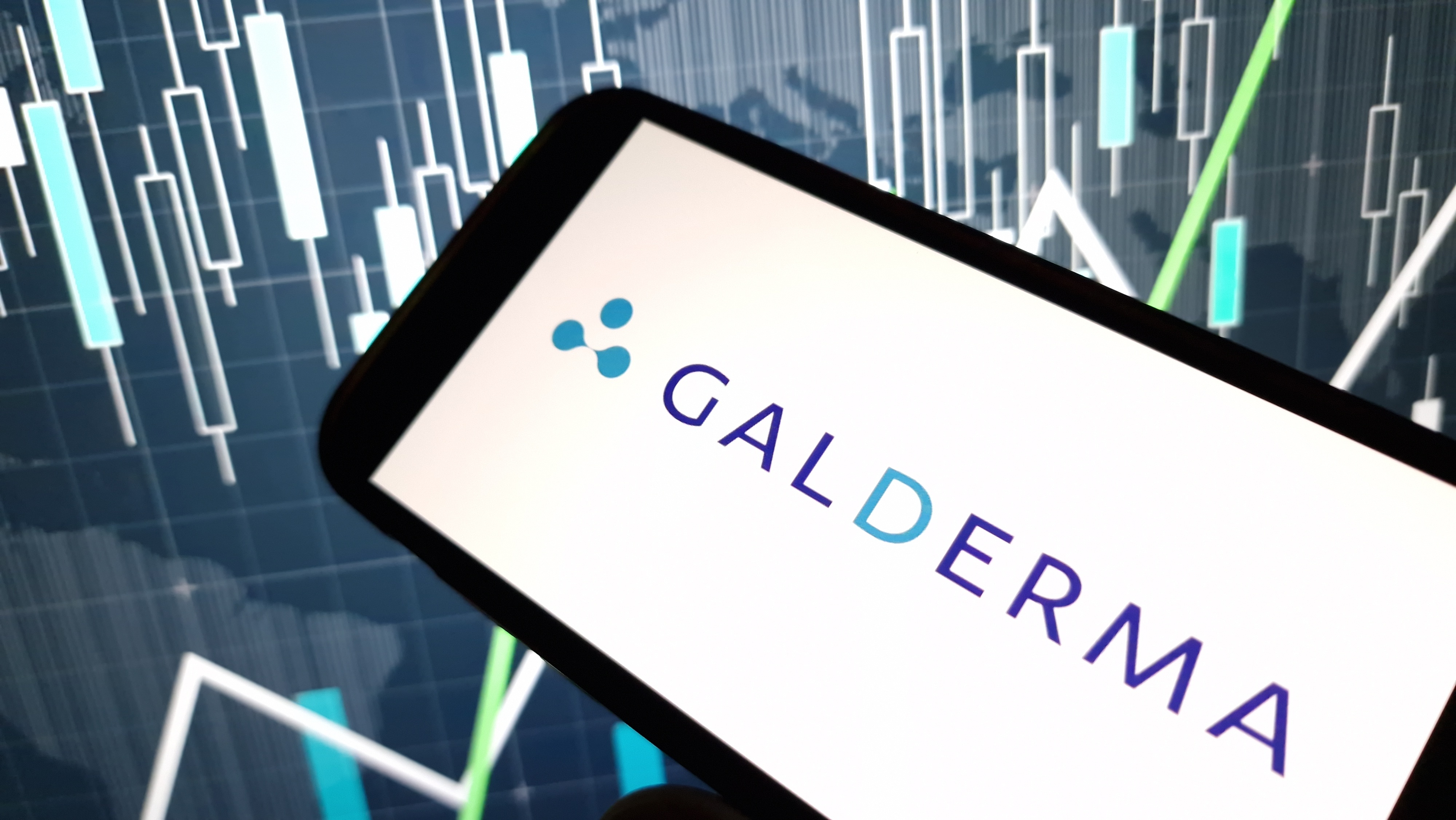 Galderma pharmaceutical company logo displayed on smartphone with financial market charts in background