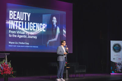 Speaker presenting 'Beauty Intelligence' talk on stage with projected slide featuring Perfect Corp branding